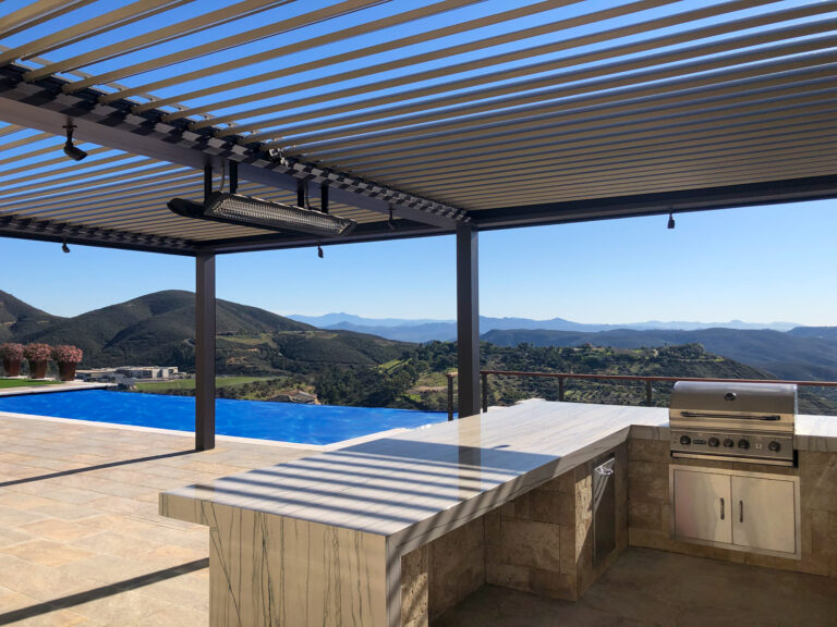 Equinox louvered patio cover in San Diego California over patio with outdoor kitchen and barbecue overlooking pool and mountains